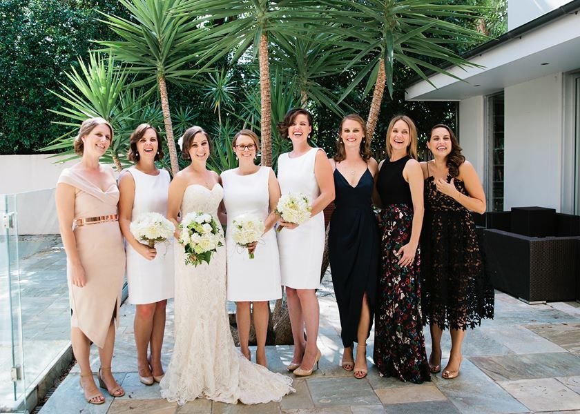 Bride and bridesmaids in elegant dresses, all smiling and ready for the wedding