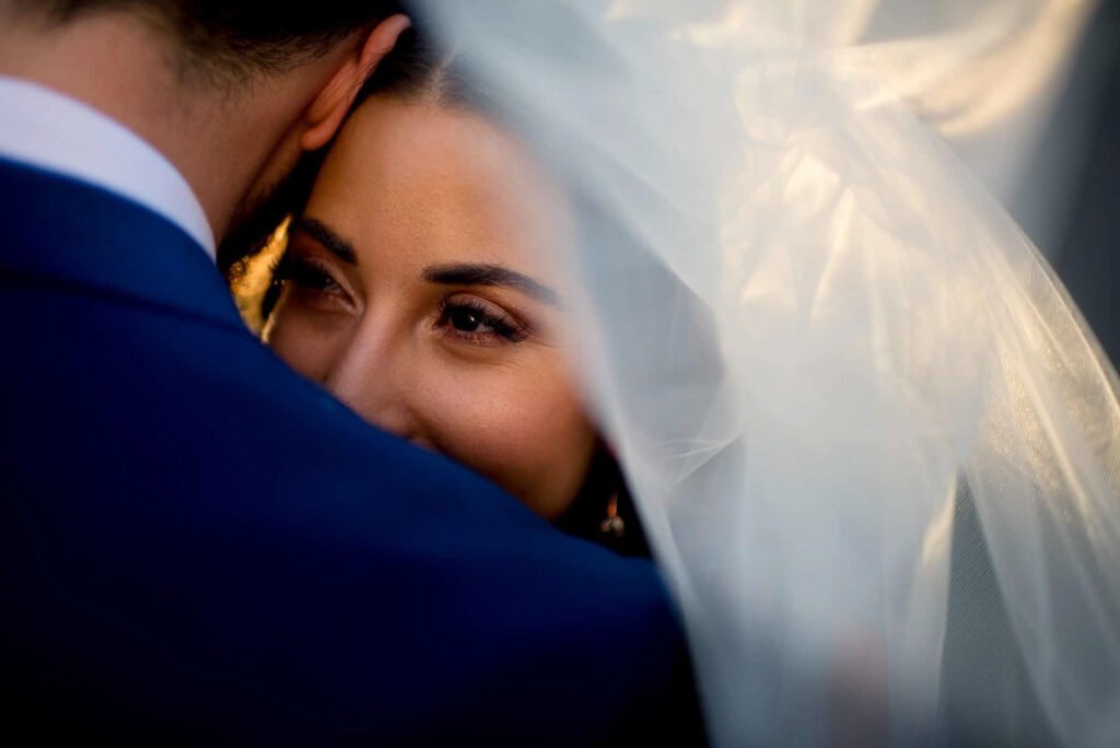 Bride with natural makeup smiling under her veil on her wedding day in Orange NSW