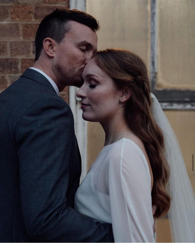 Groom kissing his bride’s forehead during an intimate moment on their wedding day.