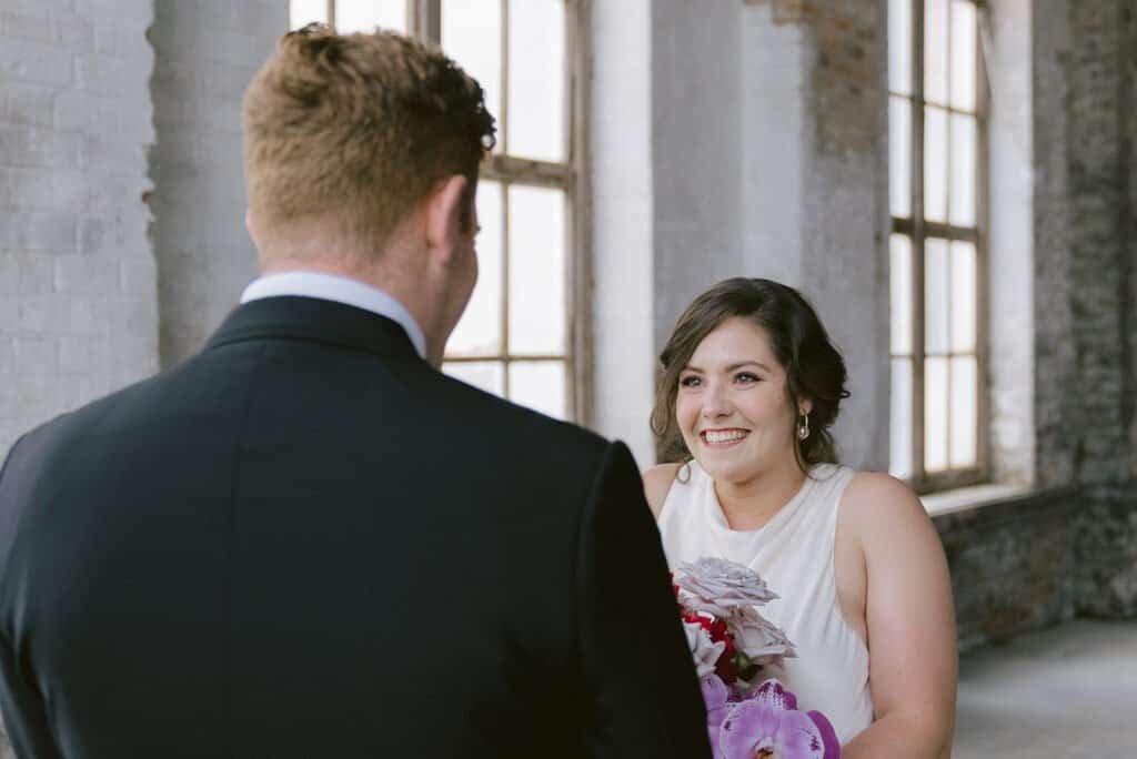 Bride smiling at groom at The Foundations, Portland with natural, minimal makeup highlighting her features.